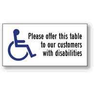 Package of 6 Transparent Labels for Restaurant Tables- with Wheelchair Symbol (ISA) and text reading: Please offer this table to our customers with disabilities- 4x2